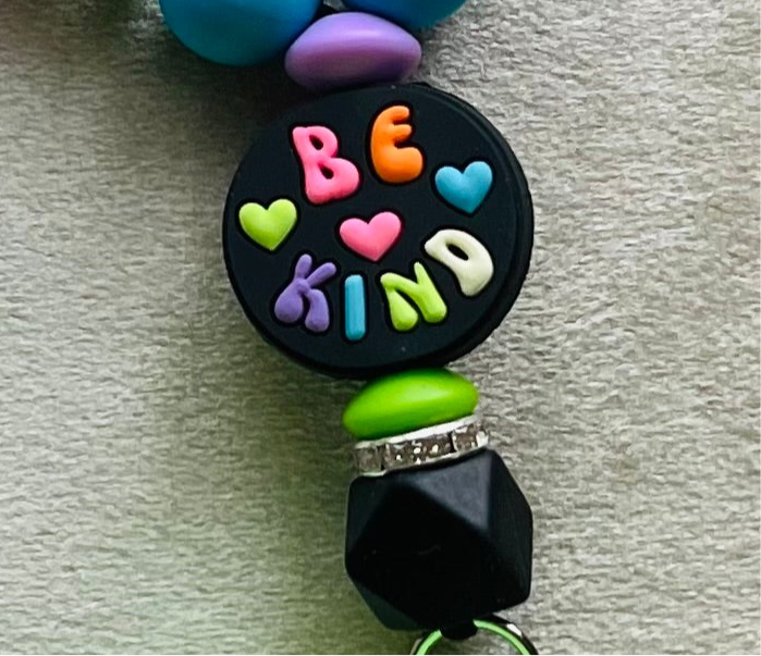 Be Kind wristlet keychain with colorful silicone beads. 'Be Kind' text on focal bead. Lime green puff ball keychain