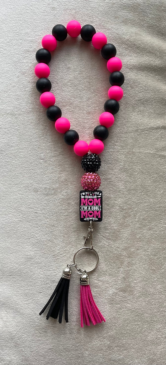 Hot pink and black silicone beads with hot pink and black tassels wristlet keychain with "Mean Girls" movie quote. "I'm not like a regular mom, I'm a cool mom" text on a silicone focal bead. Bling beads
